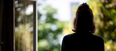 Frau blickt aus dem Fenster