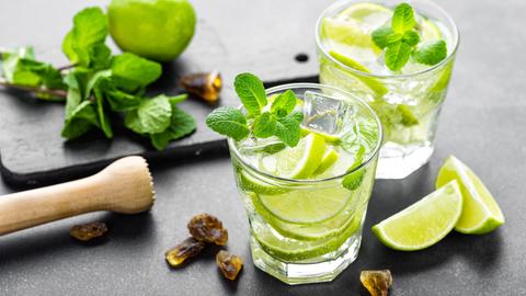 Cocktails und Utensilien auf einer Küchenplatte