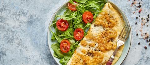 Ein Omelette mit Käse, dazu Ruccolasalat und Cherry-Tomaten. 