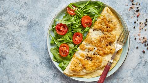 Ein Omelette mit Käse, dazu Ruccolasalat und Cherry-Tomaten. 