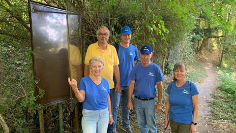 Die NABU-Gruppe Nieder-Eschbach steht vor einem der kaputten Schaukästen. 