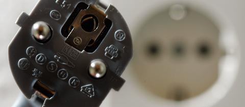 Stecker vor einer Wandsteckdose 