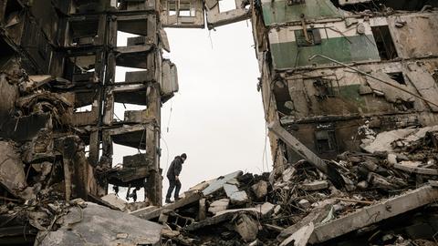 Ein Bewohner sucht in den Ruinen eines Wohnhauses, das während der Kämpfe zwischen ukrainischen und russischen Truppen zerstört wurde, nach Habseligkeiten. 